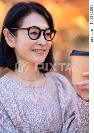 紅葉の公園を散策するミドルの女性 133381899