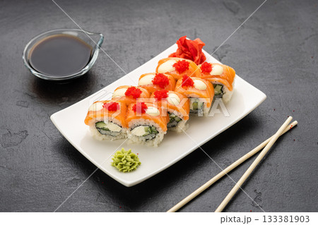 Salmon sushi rolls with cream cheese, red roe, soy sauce, wasabi and ginger, top view Salmon sushi rolls with cream cheese, red roe, soy sauce, wasabi and ginger, top view 133381903