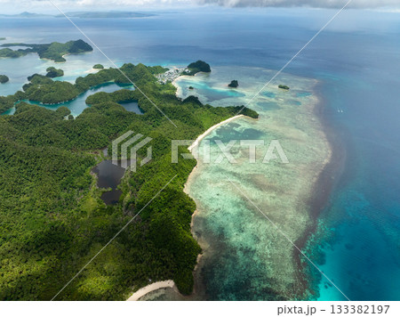 Coastal forest islands with shallow reef and village visible in distance. Siargao, Philippines. Sugba Blue Lagoon. 133382197
