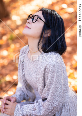 紅葉の公園を散策するミドルの女性 133382243