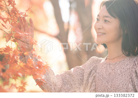紅葉の公園を散策するミドルの女性 133382372