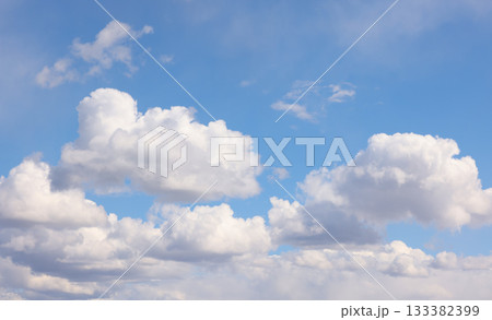Blue sky with white fluffy cumulus clouds on sunny day 133382399