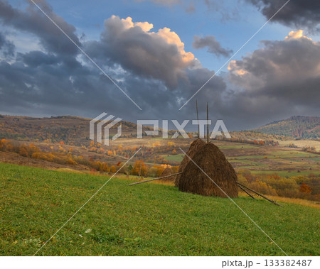 Traditional haystack standing on autumn rural hillside landscape 133382487