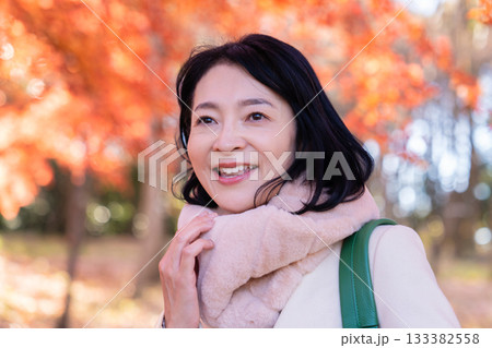 紅葉の公園を散策するミドルの女性 133382558