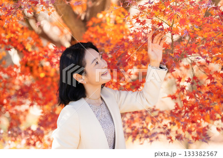 紅葉の公園を散策するミドルの女性 133382567