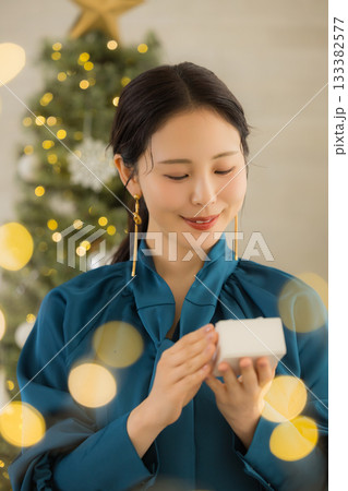 プレゼントを持つ若い女性　 133382577