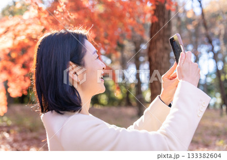 紅葉の公園を散策するミドルの女性 紅葉の公園を散策するミドルの女性 133382604