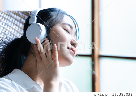 ヘッドホンで音楽を聴く若い女性 133383032
