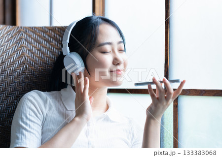 ヘッドホンでスマホ音楽を聴く若い女性 ヘッドホンでスマホ音楽を聴く若い女性 133383068