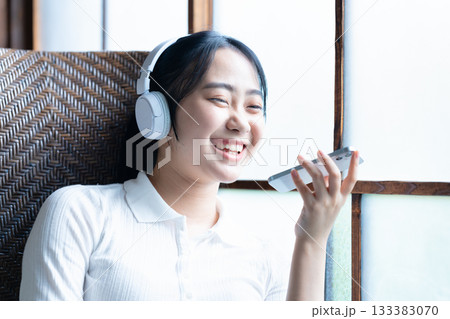 ヘッドホンでスマホ音楽を聴く若い女性 133383070