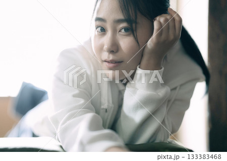 自宅で寝転んでくつろぐ女子高生 133383468