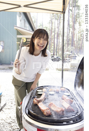 キャンプ場でBBQを楽しむ女性 キャンプ場でBBQを楽しむ女性 133384036