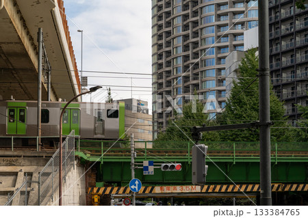 Train passing over a bridge in a modern Japanese city 133384765