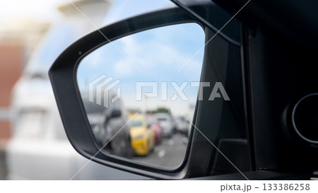 Mirror view from the side of the car. Heavy traffic during rush hour reflected in the car side mirror. Clear sky traffic conditions. 133386258