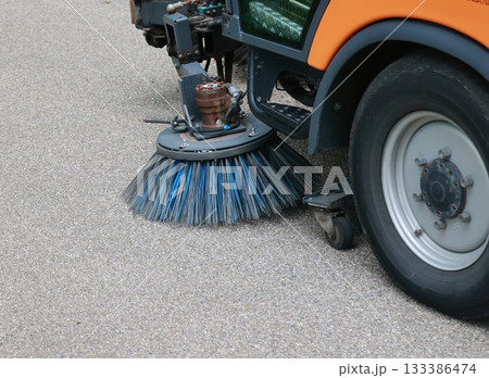 Street sweeper is cleaning the street with a blue brush 133386474