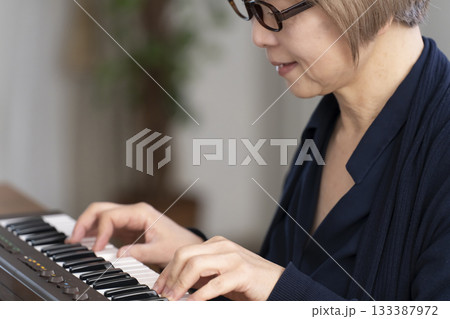キーボード弾くシニア女性 キーボード弾くシニア女性 133387972