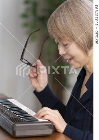 キーボード弾くシニア女性 キーボード弾くシニア女性 133387993