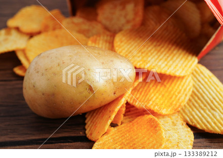 Potato chips in open bag, delicious BBQ seasoning spicy for crips, thin slice deep fried snack fast food. 133389212