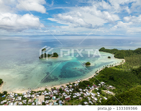 Village by the beach with turquoise lagoon and coral reef in clear tropical water. Siargao, Philippines. Sugba Blue Lagoon. 133389366