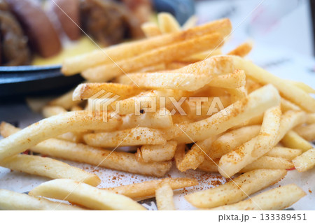 Crispy French fries with a sprinkle of seasoning served hot 133389451