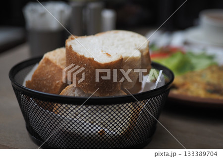 Freshly baked bread served in a basket at a cafe 133389704