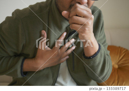 Man experiencing chest pain while sitting indoors 133389717