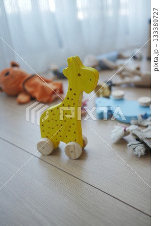 Bright yellow wooden toy giraffe on a floor  133389727