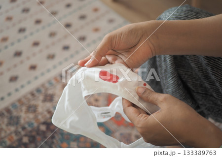 woman Hand inspecting blood stain on the white underwear 133389763