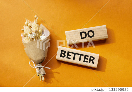 Do better symbol. Wooden blocks with words Do better. Beautiful orange background with bouquet of flowers. Business and Do better concept. Copy space. 133390923
