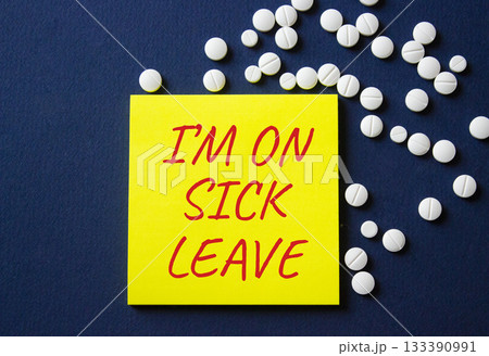 Sick leave symbol. Concept word I am on sick leave on yellow note. Beautiful deep blue background with pills. Medicine and I am on sick leave concept. Copy space 133390991