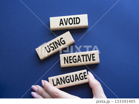 Negative Language symbol. Wooden blocks with words Avoid using Negative Language. Businessman hand. Beautiful deep blue background. Business and Avoid using Negative Language concept. Copy space. Negative Language symbol. Wooden blocks with words Avoid using Negative Language. Businessman hand. Beautiful deep blue background. Business and Avoid using Negative Language concept. Copy space. 133391405