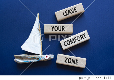 Comfort Zone symbol. Wooden blocks with words Leave your Comfort Zone. Beautiful deep blue background with boat. Business concept. Copy space. Comfort Zone symbol. Wooden blocks with words Leave your Comfort Zone. Beautiful deep blue background with boat. Business concept. Copy space. 133391411