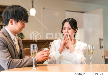 レストランでサプライズでプロポーズをする男性と驚く女性 レストランでサプライズでプロポーズをする男性と驚く女性 133391716