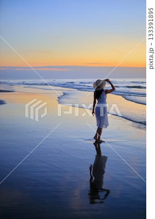 夕焼けの海を眺める彼女 133391895