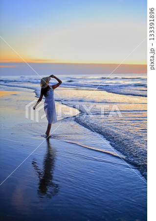 夕焼けの海を眺める彼女 133391896