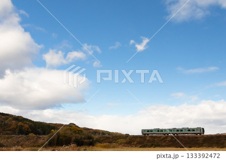 澄み切った青空と雲の下を走るローカル線 133392472