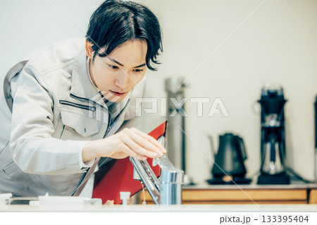 住まいの点検をする作業着を着たビジネスマン 住まいの点検をする作業着を着たビジネスマン 133395404