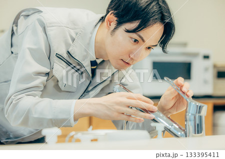 住まいの点検をする作業着を着たビジネスマン 住まいの点検をする作業着を着たビジネスマン 133395411