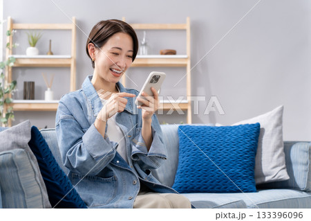 リビングでスマホを操作する女性 133396096