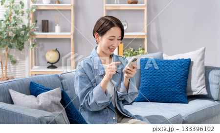 リビングでスマホを操作する女性 133396102
