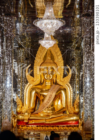 Inside the glass temple at Wat Tha Sung, Uthai Thani Province, Thailand, the room is illuminated with dazzling light, with a golden Buddha image at its center. 133398101