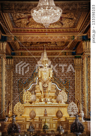 Inside the Golden Temple at Wat Tha Sung, Uthai Thani Province, Thailand, golden Thai patterns and dazzling ornaments fill the room, with a golden Buddha image at its center. 133398103