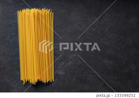 Vertical Bundle of Raw Spaghetti on Dark Background Top View Copy Space Vertical Bundle of Raw Spaghetti on Dark Background Top View Copy Space 133399252