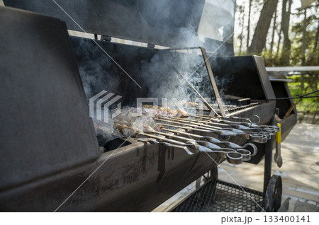 cooking meat on grill at barbecue party in summer garden in park in restaurant 133400141