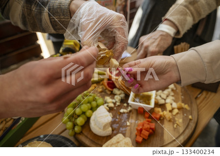 Cheese tasting at a farmers market, close-up of the hands of a seller and a buyer Cheese tasting at a farmers market, close-up of the hands of a seller and a buyer 133400234