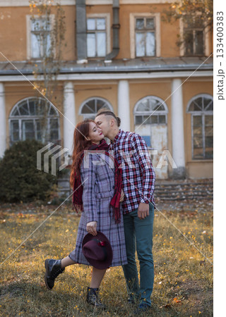 Young couple in love together in autumn park kissing and hugging Young couple in love together in autumn park kissing and hugging 133400383