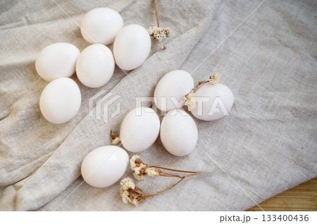 white chicken eggs lie on the table on a natural linen tablecloth 133400436