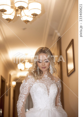 close up of beautiful blonde bride in long white dress in hotel hallway close up of beautiful blonde bride in long white dress in hotel hallway 133400621