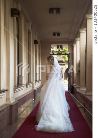 beautiful blonde bride in a beautiful hotel in an arch in a long wedding dress 133400628