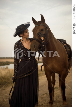 beautiful equestrian woman is walking with horse after horse riding 133400682